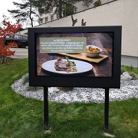 TV Gehäuse Aussenbereich auf einem Ständer vor einem Restaurant